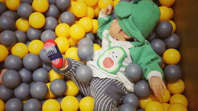 Happy toddler playing in a ball pit full of colourful balls